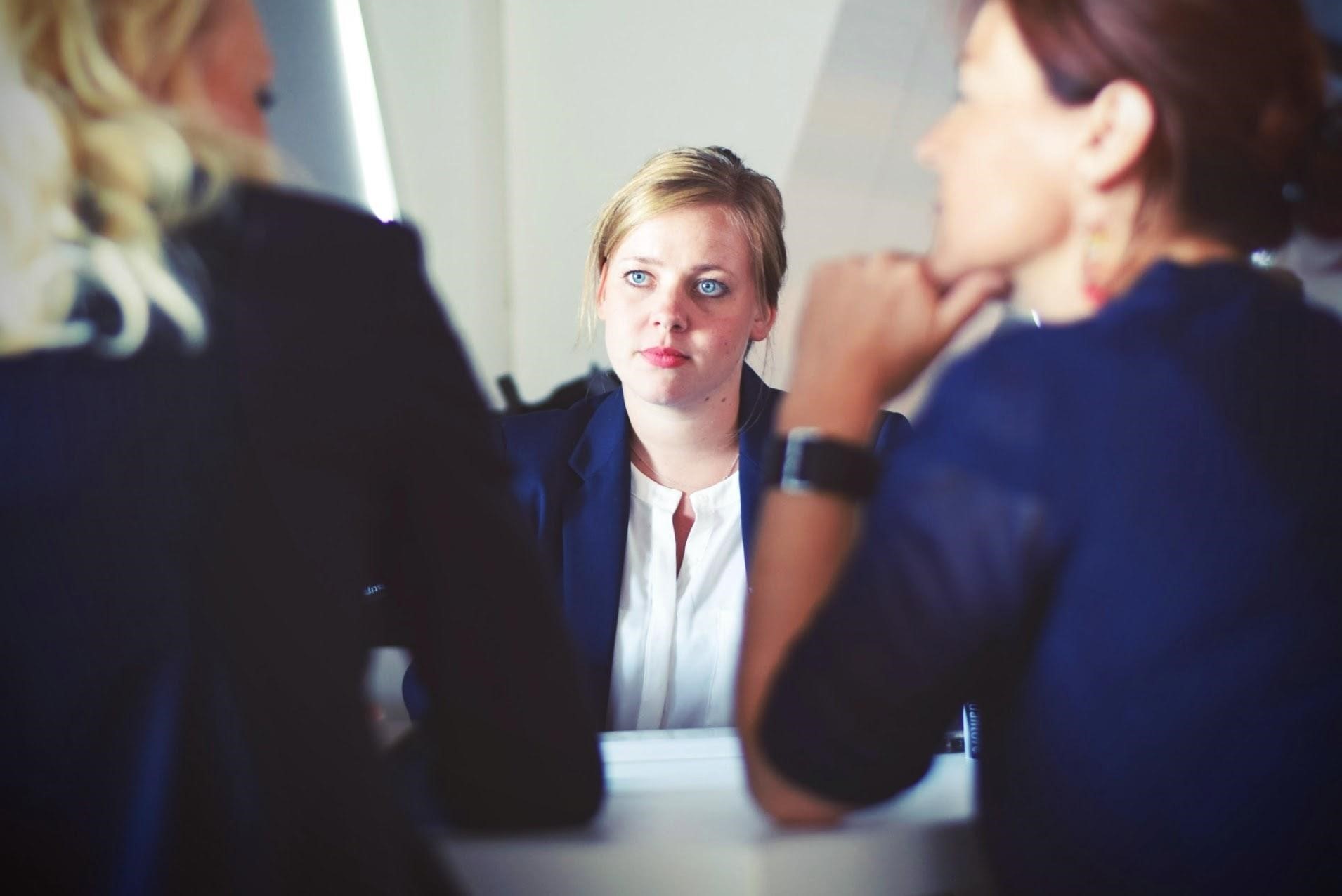 Image of three women sitting next to the table.